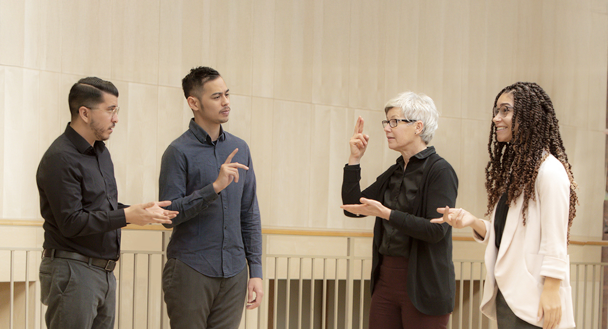 Photo of hearing person, hearing interpreter, deaf person, and deaf interpreter