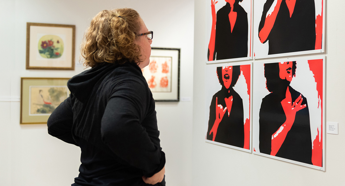 A student looks at artwork in the Dyer Arts Center