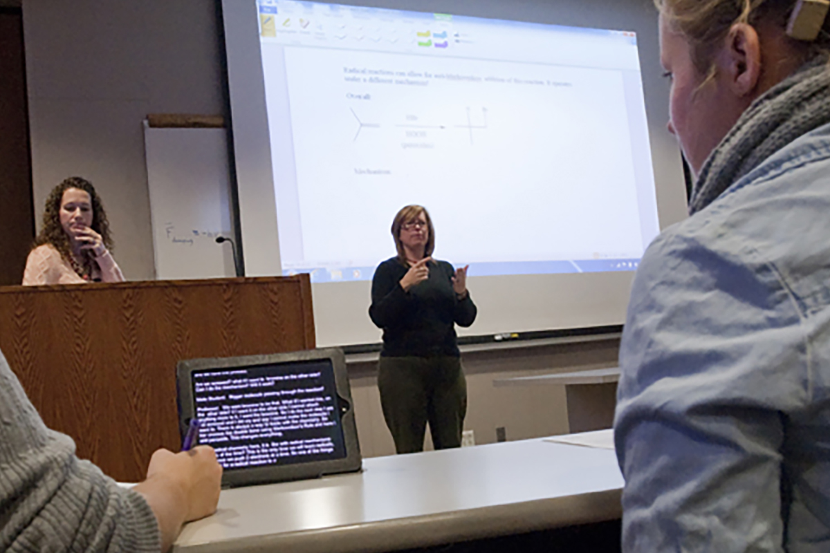 Student in classroom with captioning assistance monitor