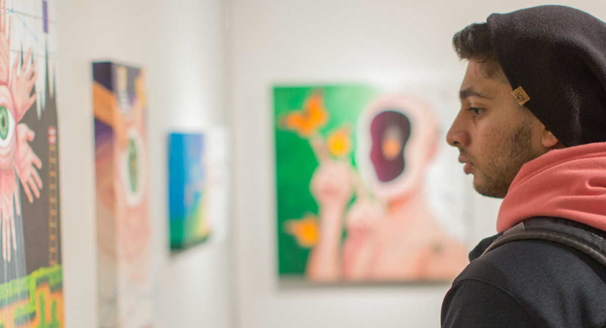 Photo of students viewing dyer arts gallery walls of paintings and drawings