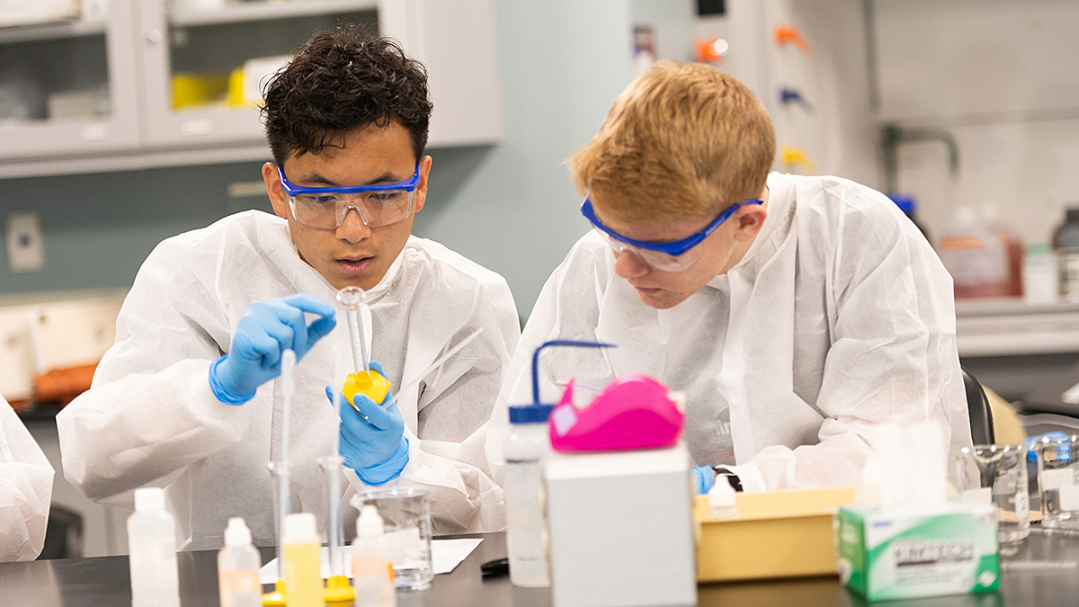 Two male students working together on a science experiment