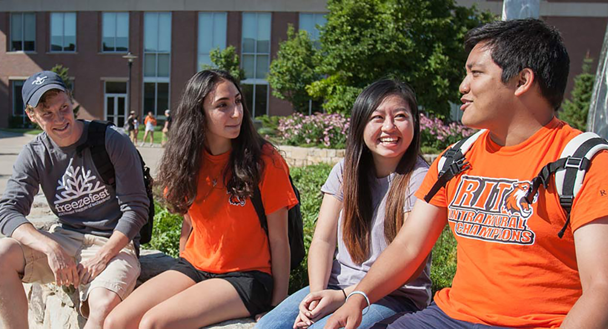 Photo of students sitting outside having a conversation