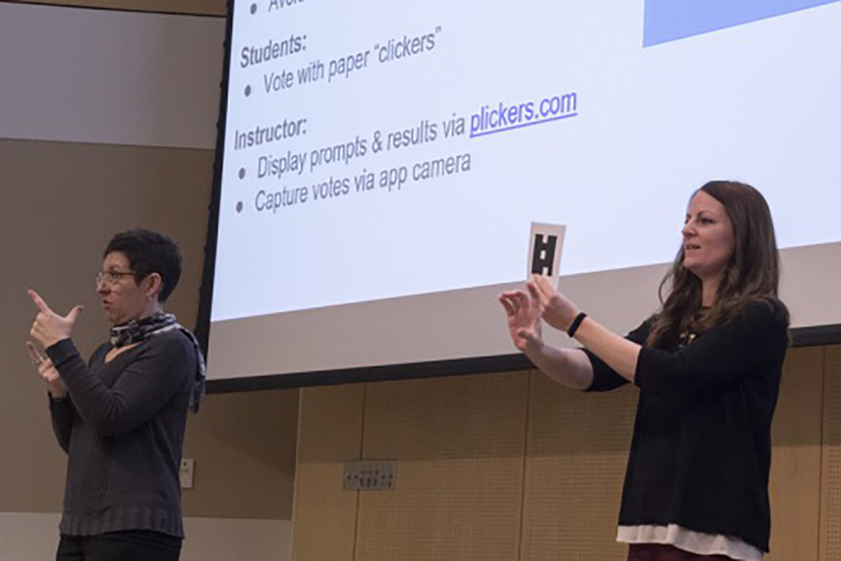 Presenter and interpreter in front of large display at presentation