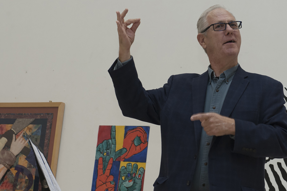 Photo of man signing in presentation at RADSCC deaf mute banquet