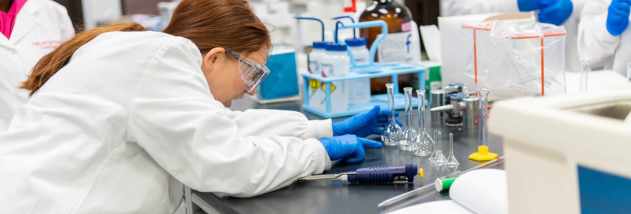 Student looking at glass beakers in a science laboratory