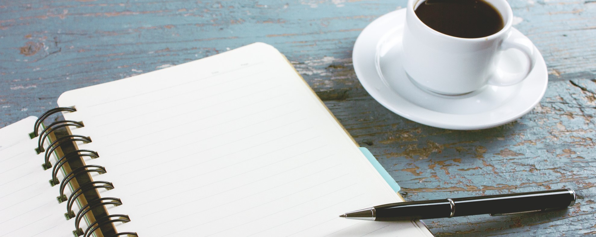 coffee, pen, journal on table surface