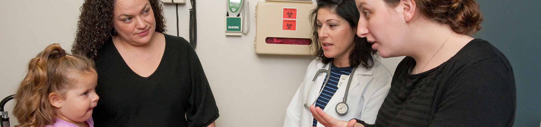 A young patient and her mother communicate with a doctor with an interpreter