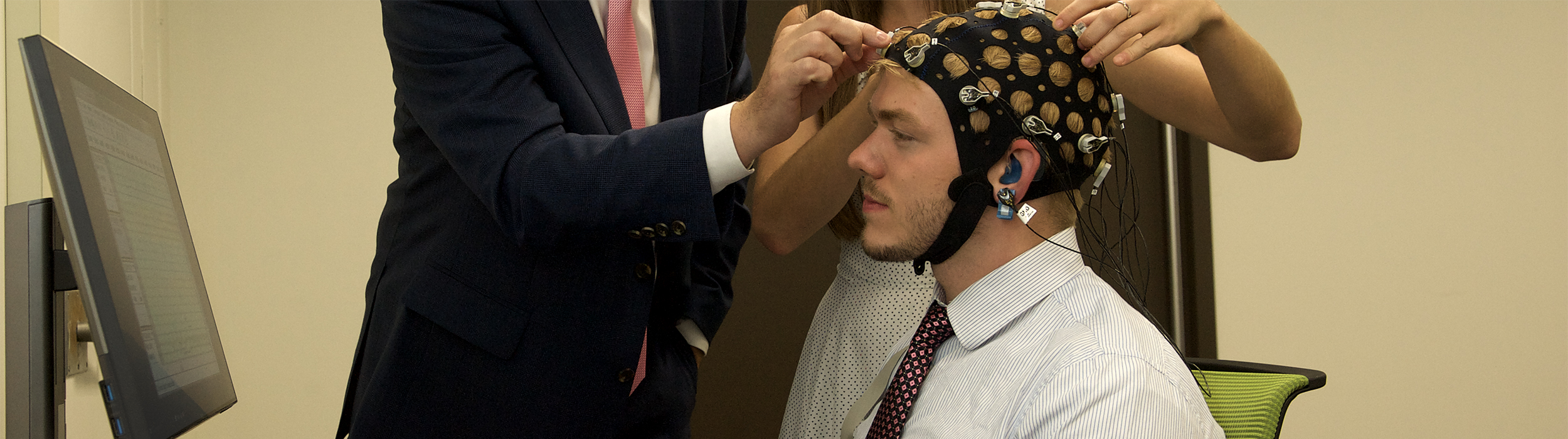 Photo of staff fitting research subject with electrode cap