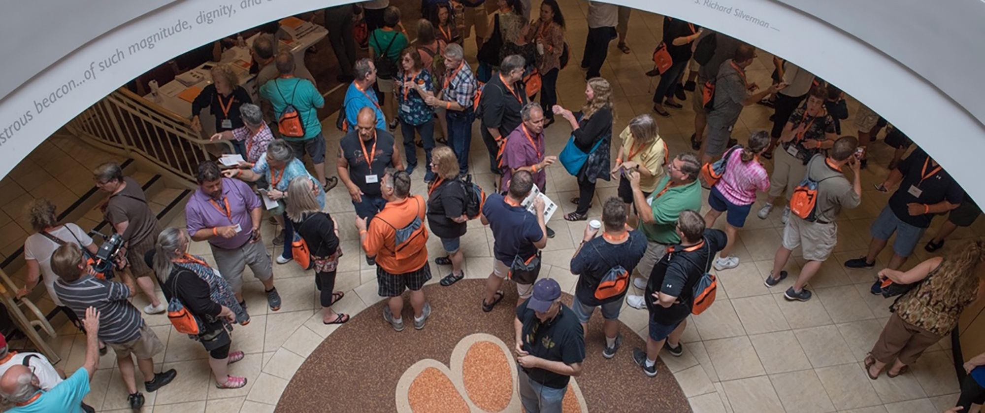 Overhead shot of alumni standing near the tiger paw print floor in the SDC lobby