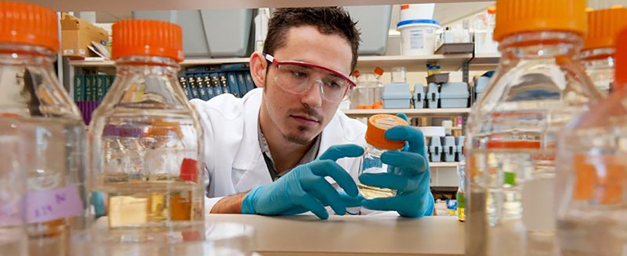 student in lab with beakers and chemicals