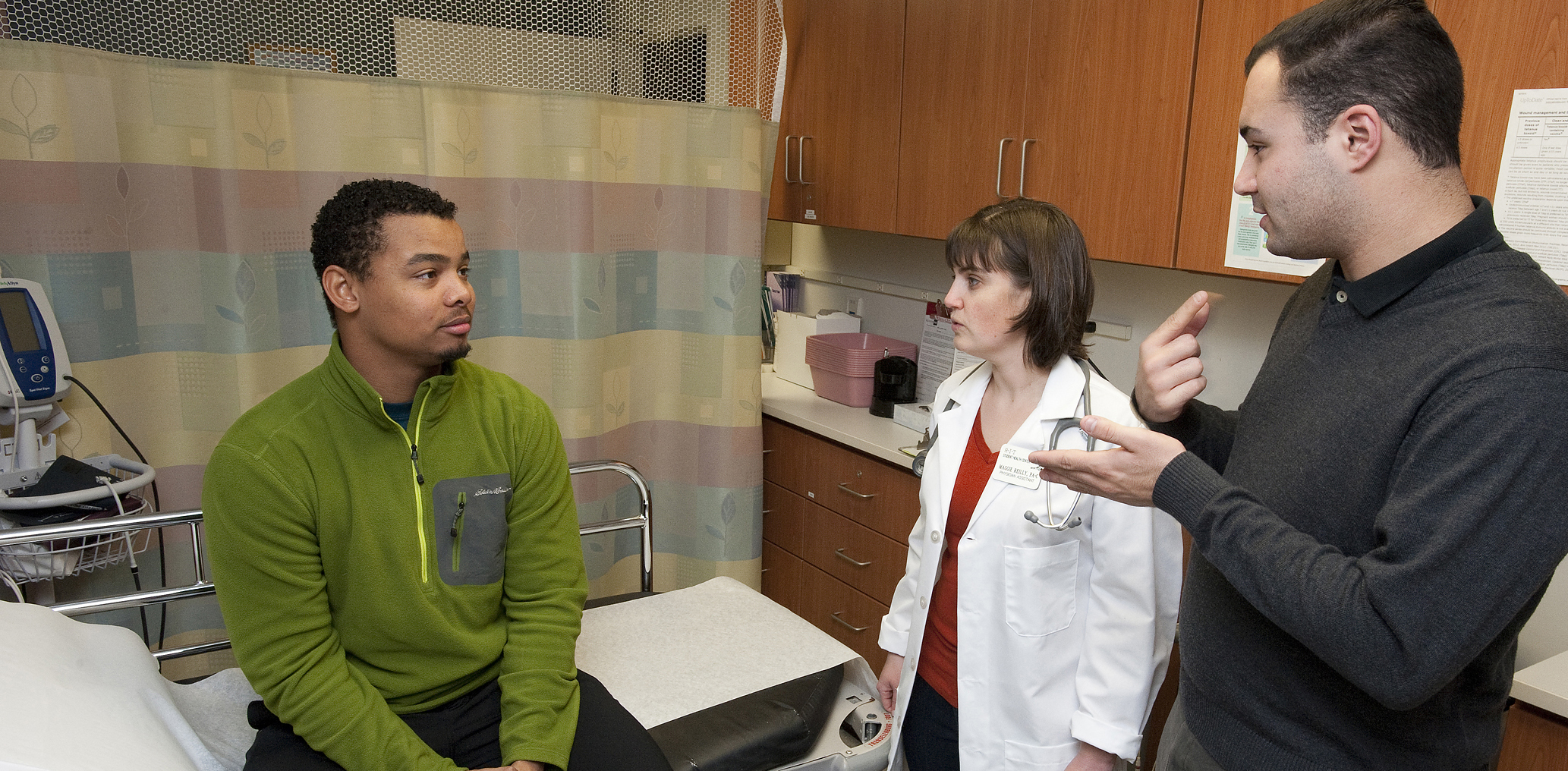 Interpreter in exam room facilitating communication between patient and health care worker