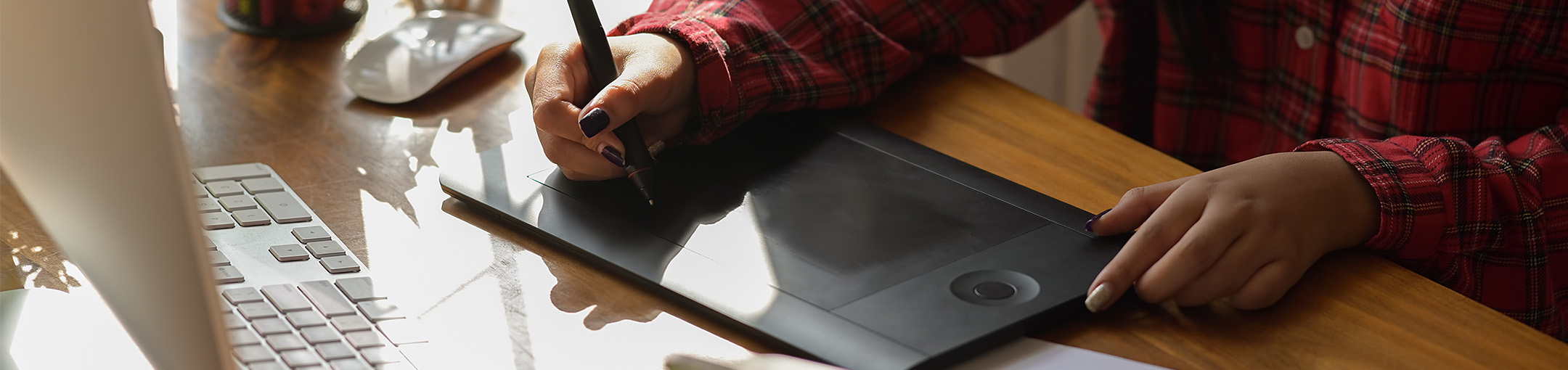 Graphic designer woman using digital graphic tablet while working in office