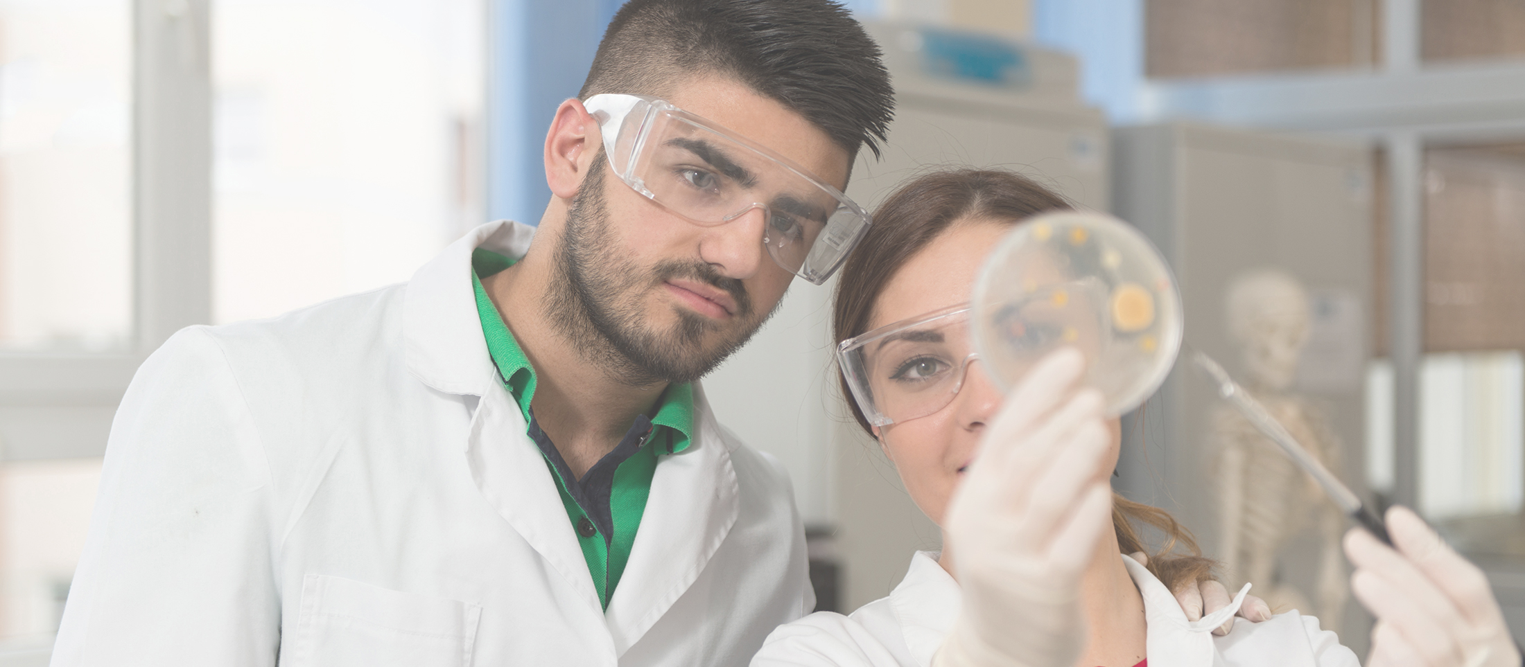 Graphic with words "Research Initiative for Scientific Enhancement" and three people looking a petri dish