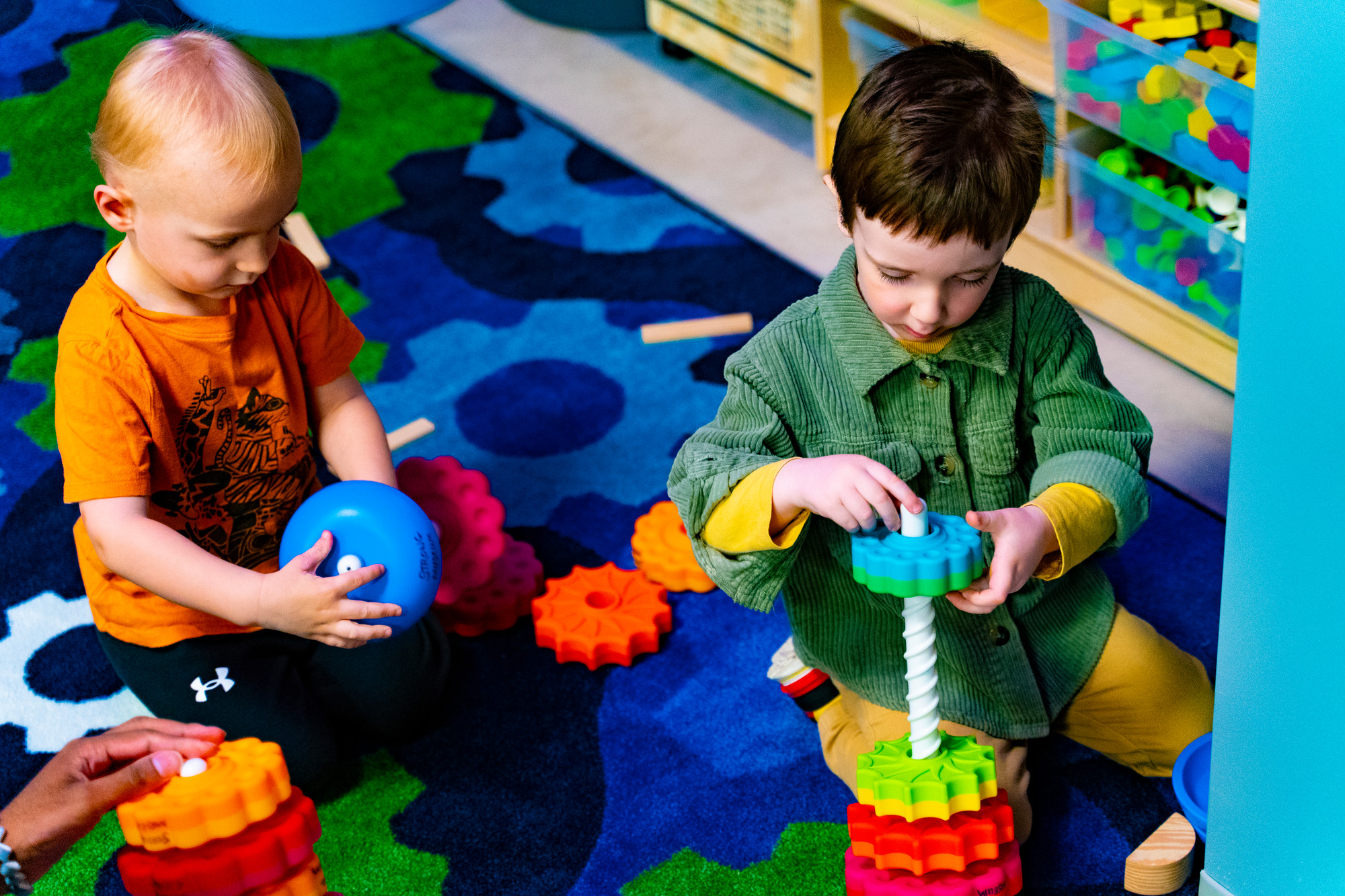 Children playing with colored cogs and toys in Play Lab