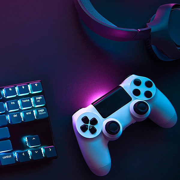 Top down view of colorful illuminated gaming accessories laying on table. Professional computer game playing, esports business and online world concept