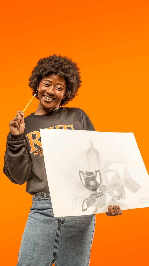 Rebecca Adeyinka holding her artwork