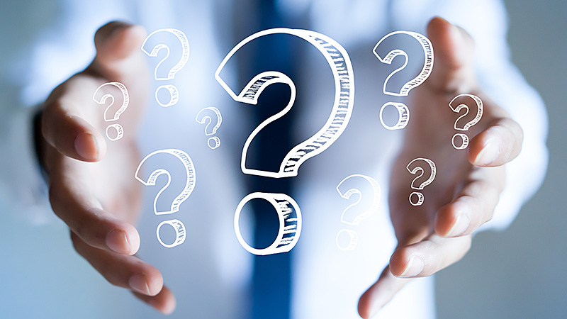 Businessman with question marks in his hand.