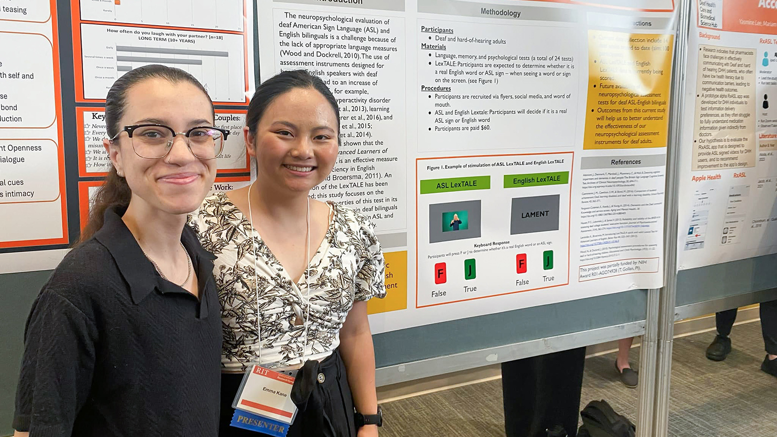 Two students standing in front of their poster session displays