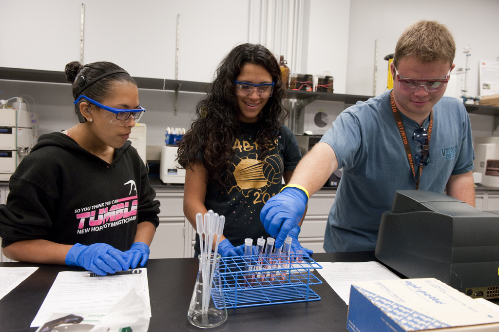 Three students performing a science experiment