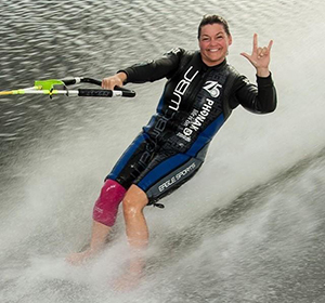 Karen Putz water skiing and giving 'ILY' sign.