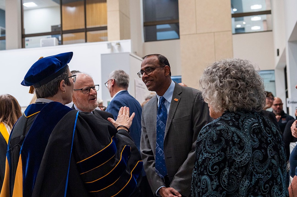 Group of people conversing indoors during a reception.