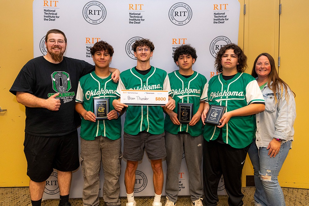 Second-place esports team 'Bison Thunder' wearing matching green Oklahoma jerseys holding plaques and an $800 prize check.