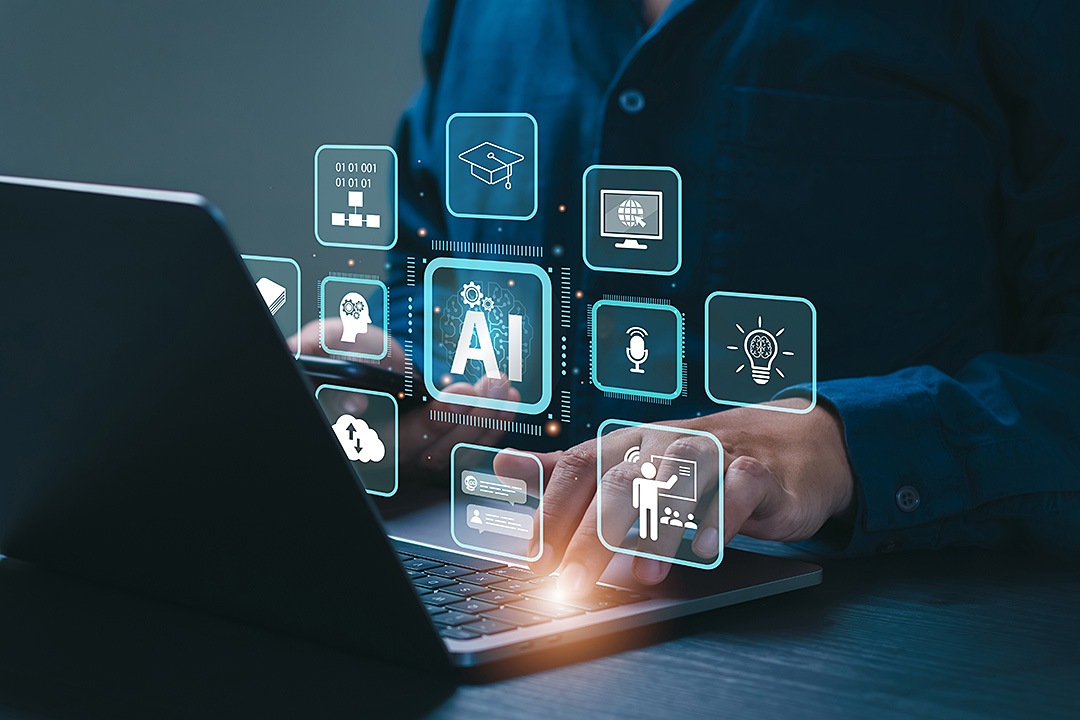 A close-up of a person’s hands using a laptop, with a glowing, futuristic digital overlay of various educational and artificial intelligence icons. Central to the display is a large "AI" icon with a brain graphic, surrounded by smaller symbols for graduation caps, lightbulbs, global networks, and online lectures.