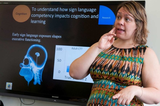 Woman signing in front of a presentation 