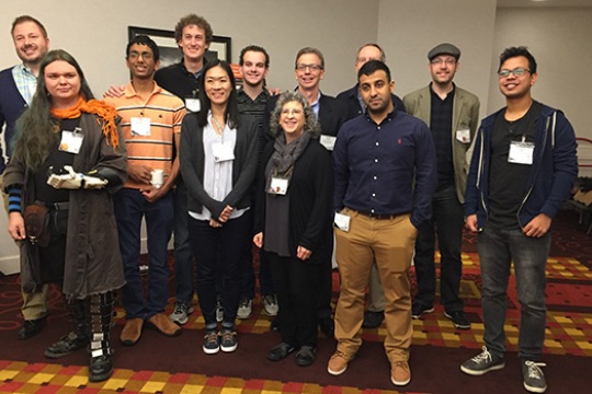 A group of RIT faculty and students stand and pose for a photo.