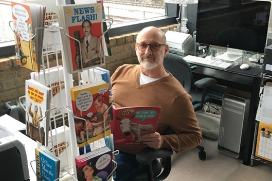 Jay Blumenfeld sitting next to magazine rack.