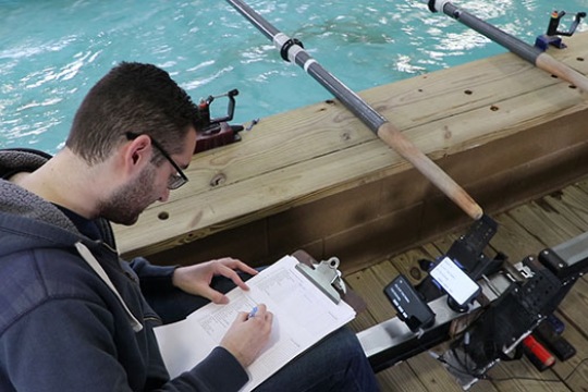 Person writing on a clipboard inside of a row boat.