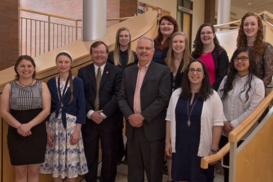 Students pose for a photo on a staircase with president Gerry Buckley.