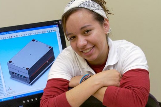 Student posing in front of computer model