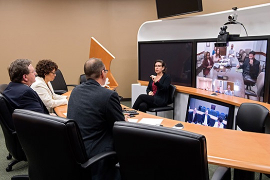 People gathered in conference room using camera to converse