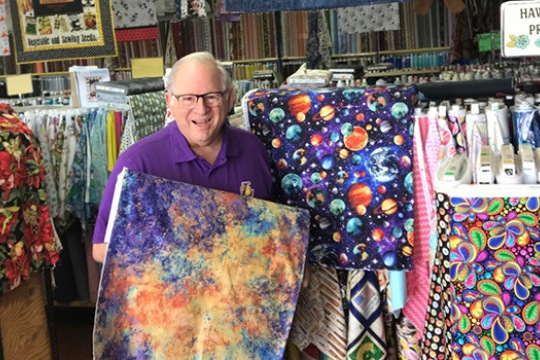 Richard Potter surrounded by different fabrics.