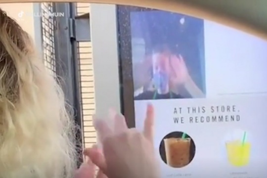 customer and employee using sign language at a Starbucks drive-through.