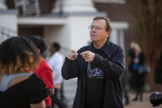 person pointing at a student.