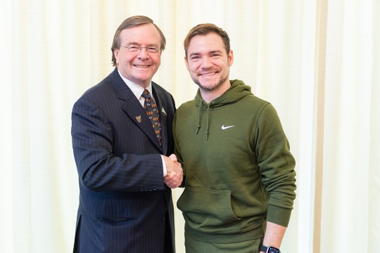 two people shaking hands and smiling.