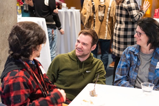 three people smiling at a reception table.