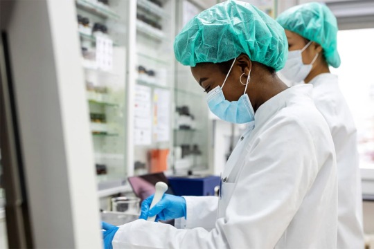 scientist wearing a lab coat and hair net.