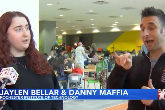 a male and female are interviewed by WHEC-TV. The male on the right is signing and the female on the left is interpreting.