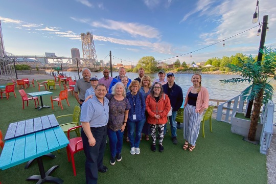 A group photo of alumni gathering at Buffalo RiverWorks on a beautiful blue-sky evening. Photo credit: Sara Smania