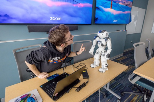 a student interacts with a robot