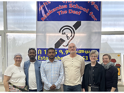 Photo of Matt Dye and others in front of banner