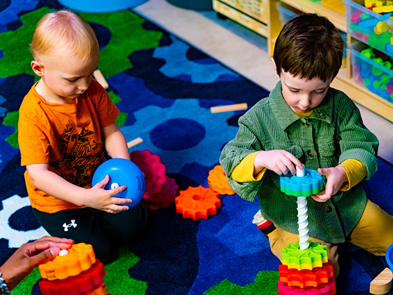 Children playing with colored plastic gears.