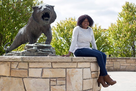 Person posing near tiger statue