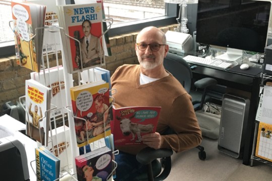 Jay Blumenfeld sitting next to magazine rack.