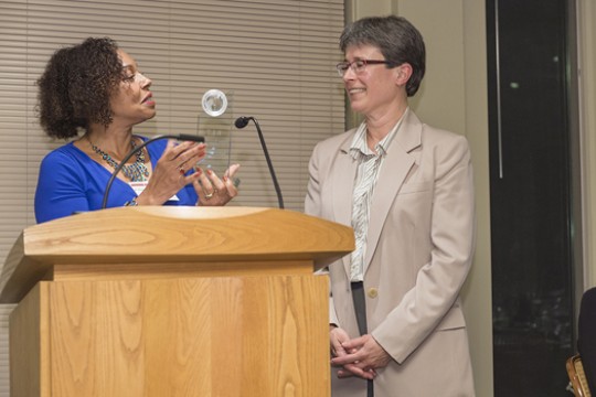 Person giving award to Professor on stage