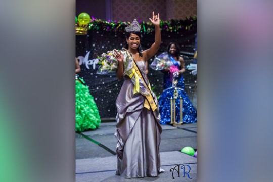 Person posing on stage at event