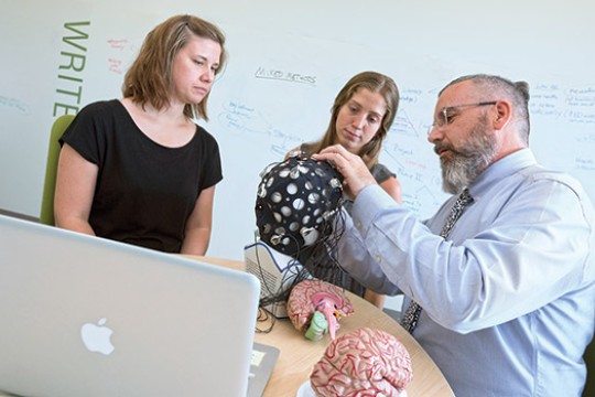 People looking at signal device